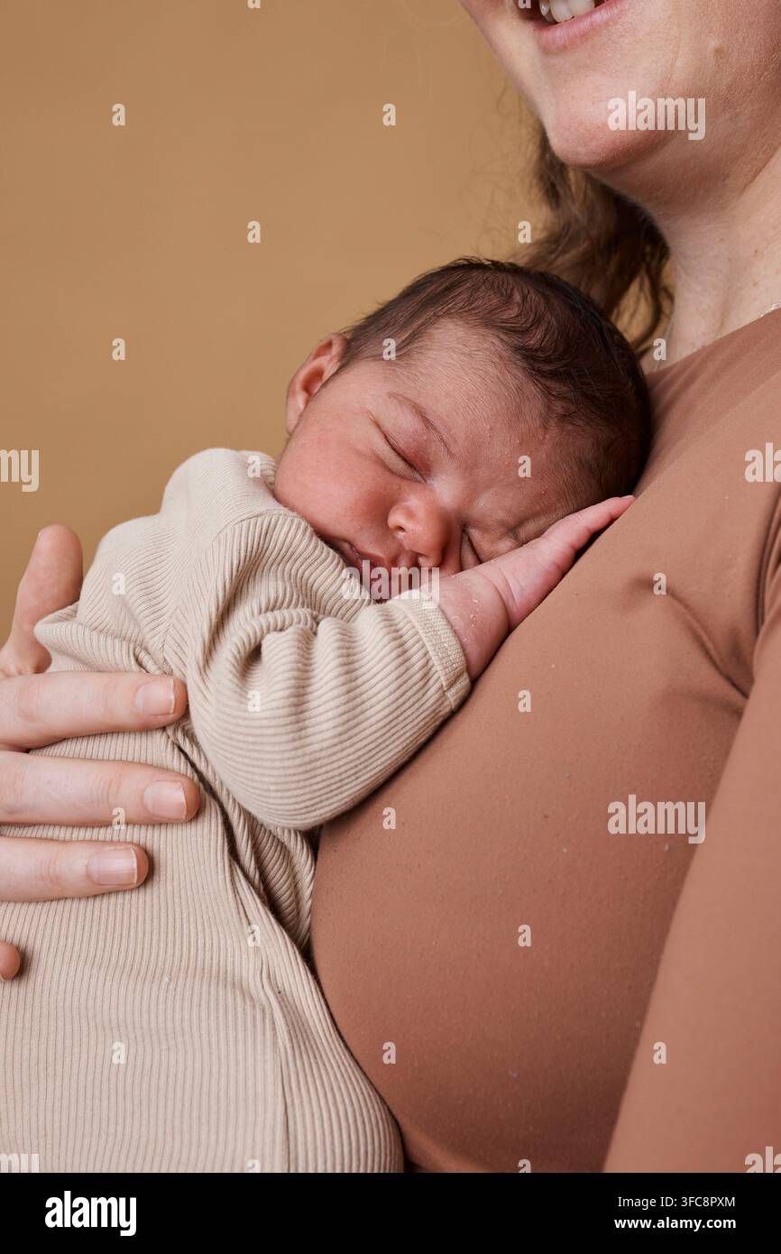 Nouveau-né tendre dormant sur la poitrine de sa mère dans un portrait de famille interracial, moment de lien multiracial Banque D'Images