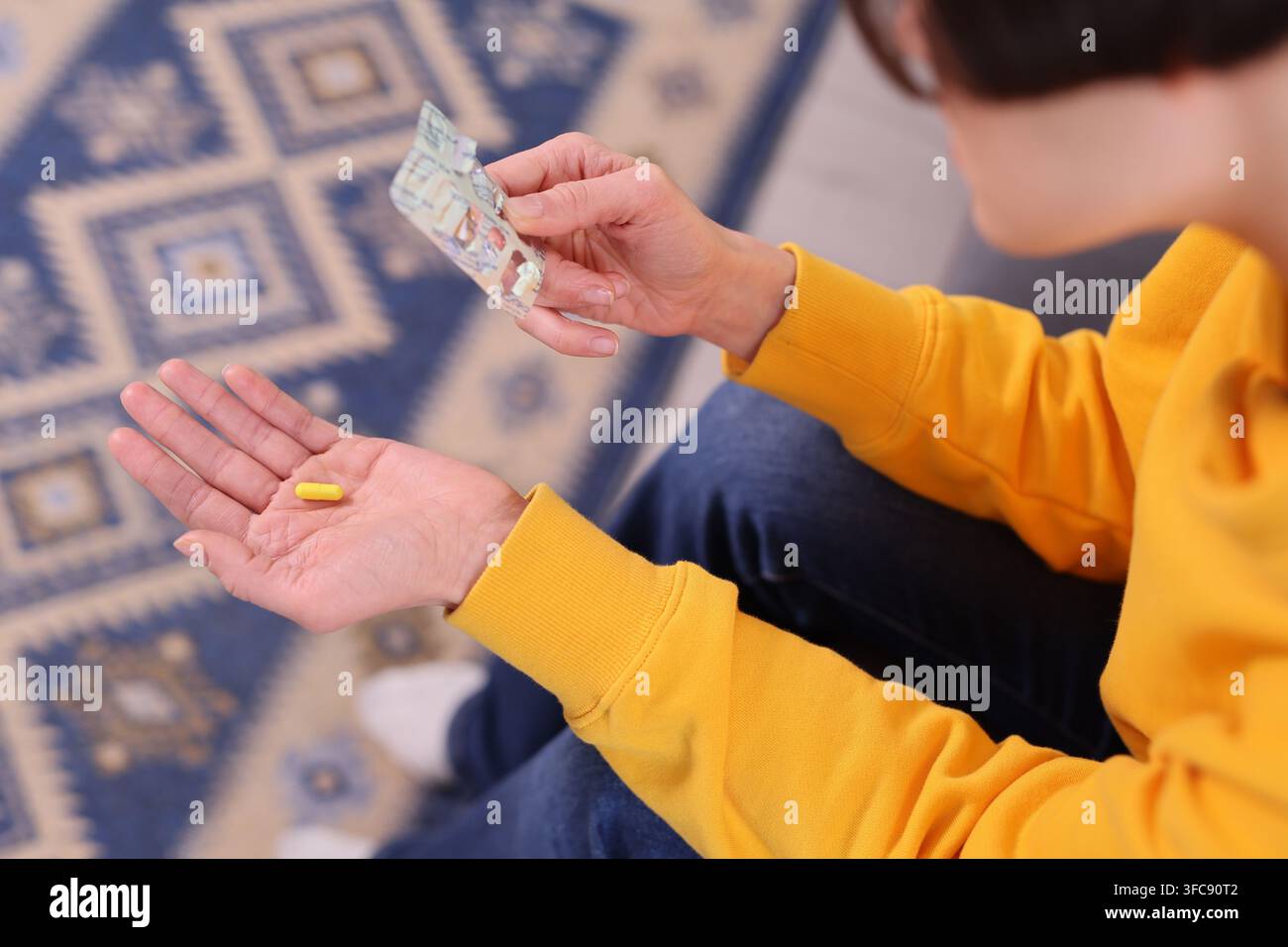 Femme tient une tablette dans la paume de sa main et se prépare à prendre des médicaments Banque D'Images