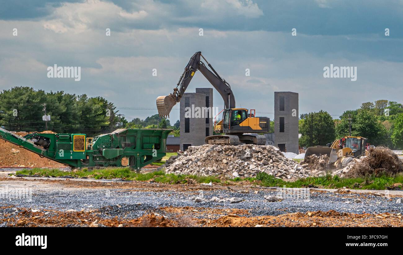 Des machines lourdes opèrent sur un chantier de construction où les ouvriers se préparent pour un nouveau développement immobilier. De gros équipements déplacent la terre et les matériaux autour t Banque D'Images