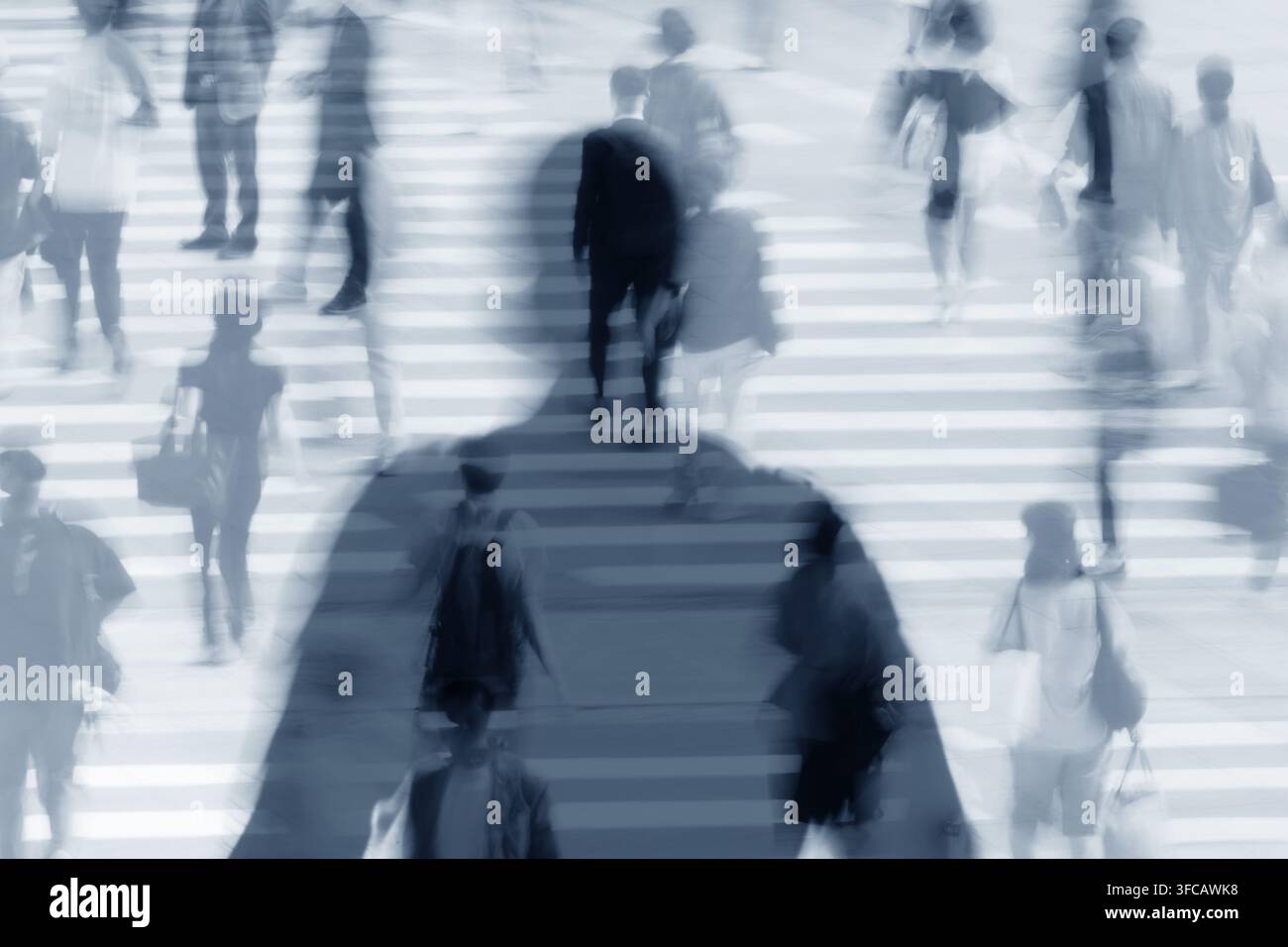 Silhouette d'une personne dans la foule sur un passage piétonnier urbain animé. Banque D'Images