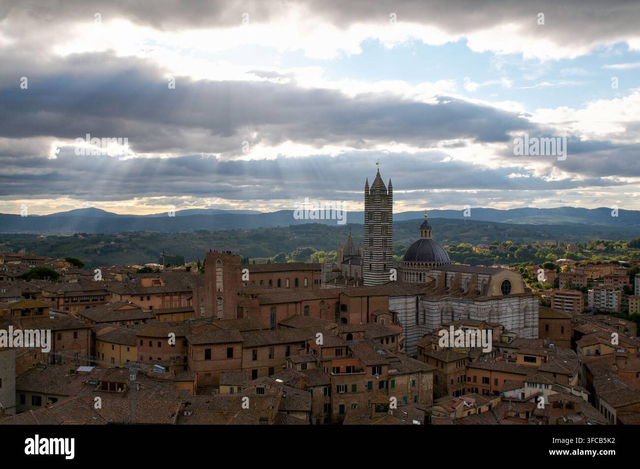 Sienne, Toscane, Italie - 8 octobre : Vue panoramique de la cathédrale de Sienne et des toits historiques avec des rayons de soleil traversant les nuages Banque D'Images
