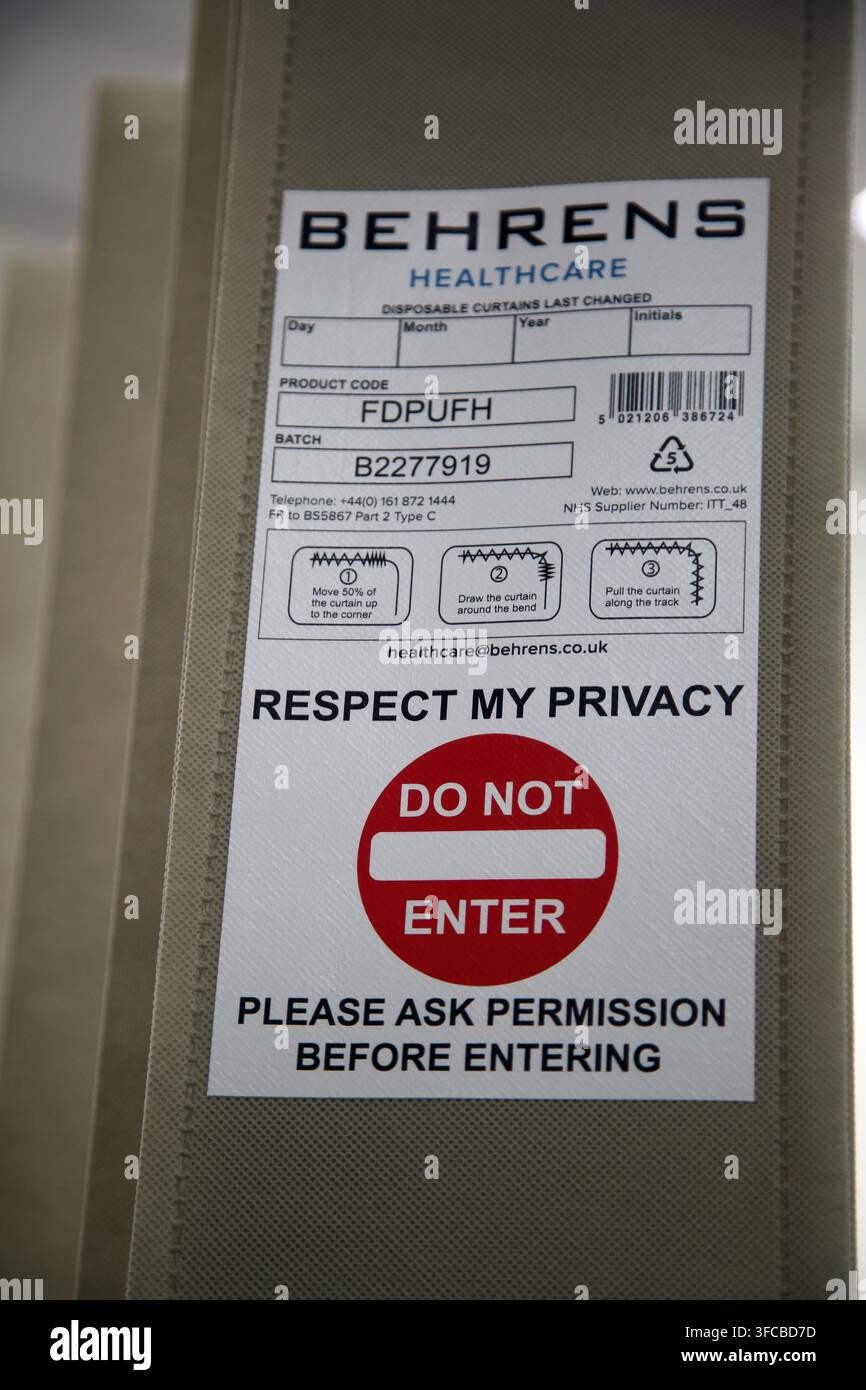 Un panneau « Do Not Enter Respect my Privacy » sur les rideaux autour d'un lit d'hôpital à Surrey, Angleterre Banque D'Images