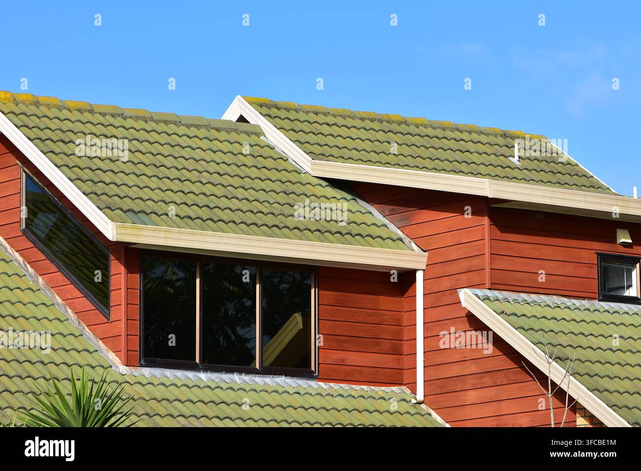L'image semble montrer une résidence moderne à plusieurs niveaux dotée de tuiles de toit en béton entrelacées (rappellant un Double Romain classique ou similaire Banque D'Images