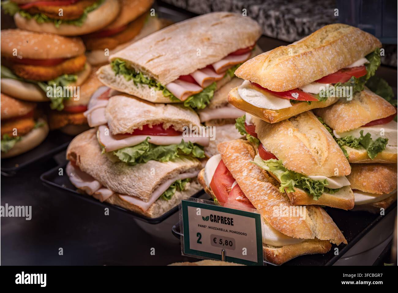 Sandwiches italiens Caprese en baguette avec mozzarella tranchée, tomates fraîches et laitue verte dans une vitrine d'un café, Vintimille, Italie Banque D'Images