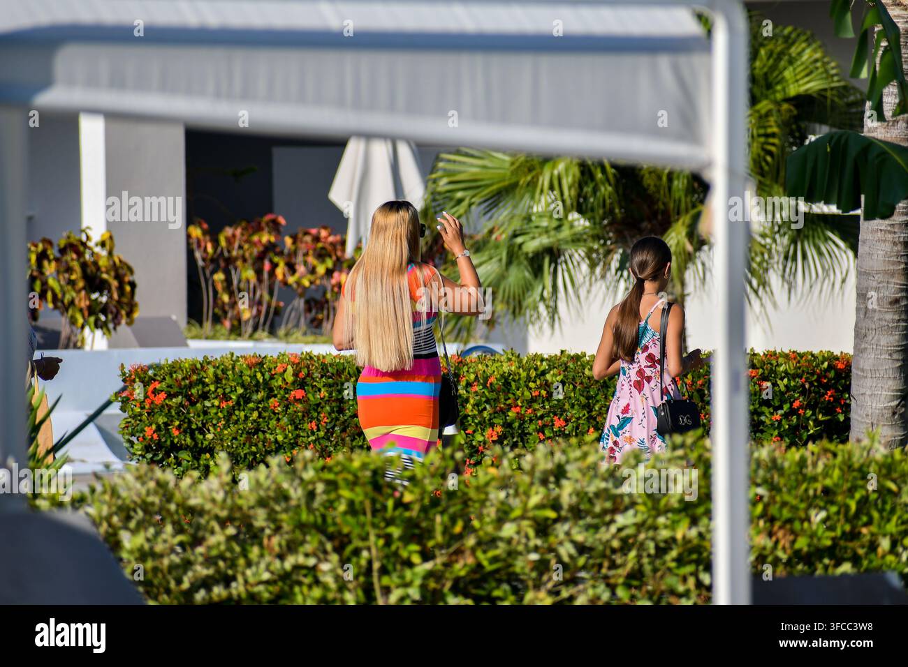 TRINIDAD, CUBA - JUILLET 2026 : Deux femmes en robes colorées traversant la zone jardin du resort Melia Trinidad Peninsula. Banque D'Images