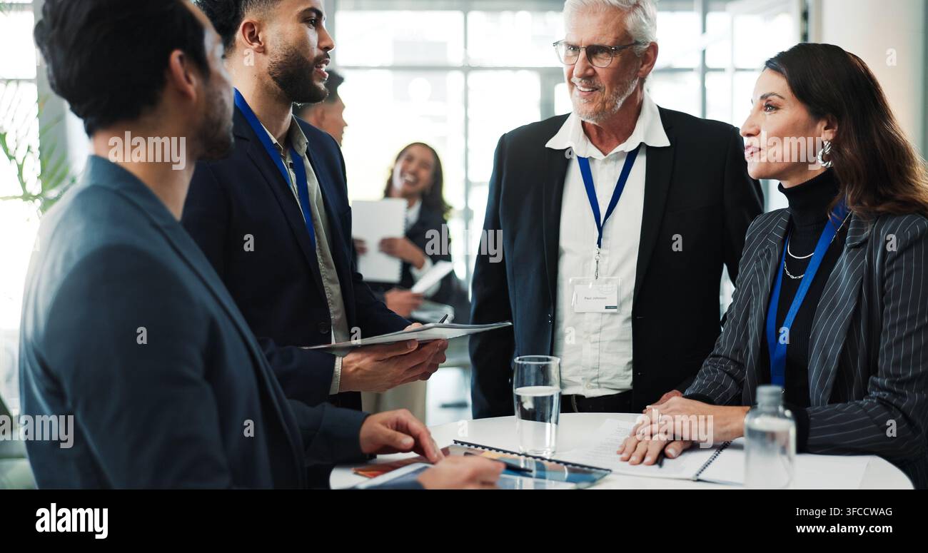 Sourire, affaires et personnes lors d'un séminaire avec dossier, présence et enregistrement pour l'enregistrement. Heureux, équipe et discussion au bureau avec document Banque D'Images
