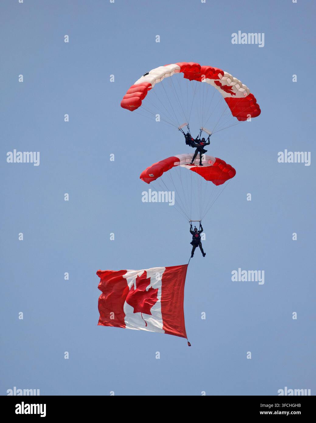 SkyHawks, les parachutistes des Forces armées canadiennes effectuent un saut synchronisé avec un drapeau national lors du Red Deer Airshow, au Canada Banque D'Images