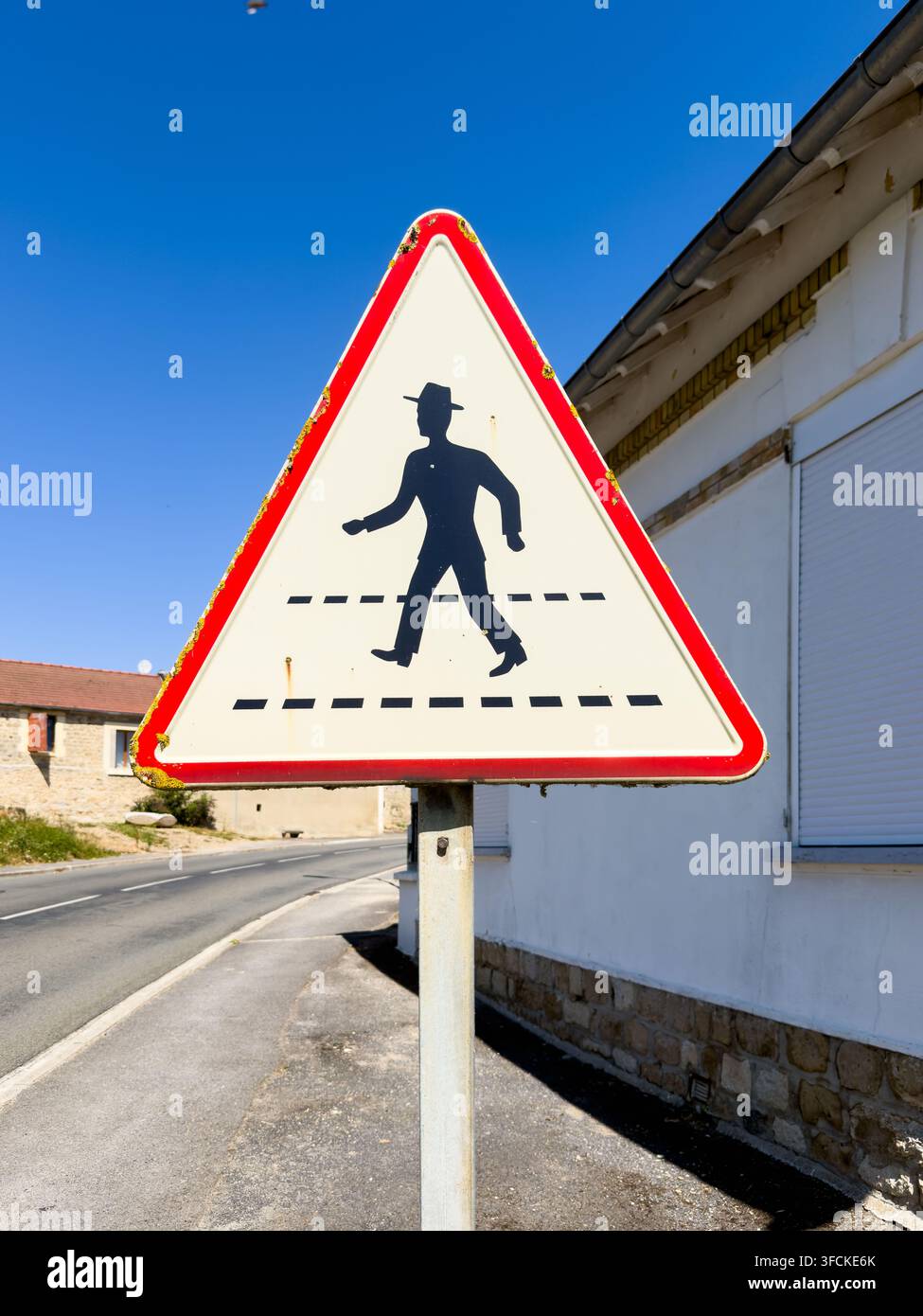 Panneau de passage piéton situé sur une rue dans un quartier résidentiel des Pays-Bas avec des maisons et un ciel bleu clair en arrière-plan Banque D'Images