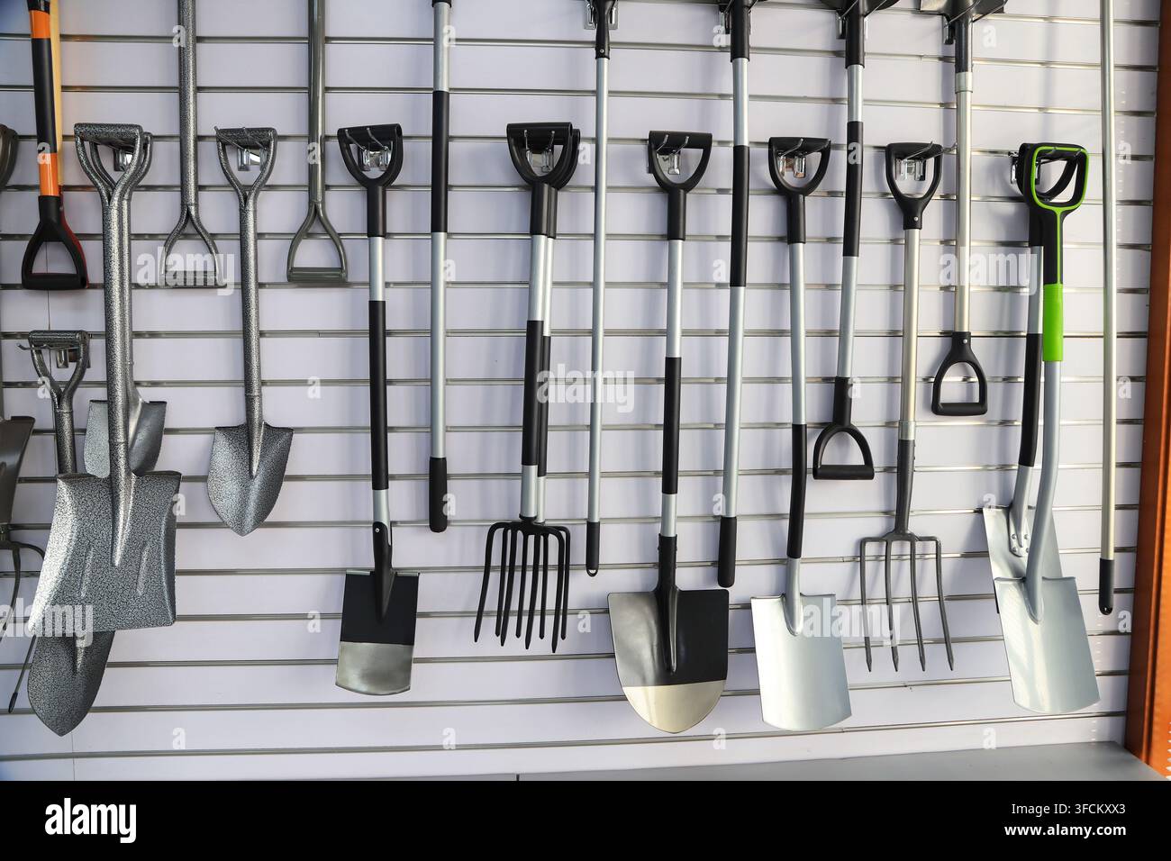 Image en gros plan haute résolution capturant une variété d'outils de jardinage comprenant des pelles, des pioches, des fourches et des râteaux de jardin soigneusement disposés sur un fond blanc Banque D'Images