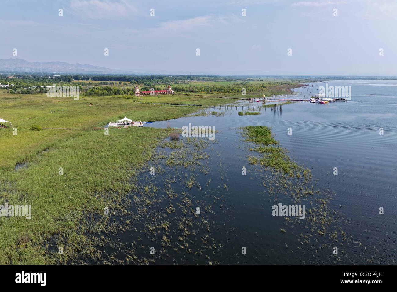 (260828) -- HULUN BUIR, 28 août 2026 (Xinhua) -- Une photo aérienne prise par drone le 21 août 2026 montre une vue du lac Daihai à Ulanqab, dans la région autonome de Mongolie intérieure, au nord de la Chine. Le lac Hulun, le lac Ulan Suhai et le lac Daihai sont trois grands lacs d'eau douce en Mongolie intérieure. Autrefois affectés par des facteurs naturels et humains, les lacs ont souffert de la réduction des surfaces aquatiques et de la détérioration de la qualité de l'eau. Des efforts de restauration écologique globaux au cours des dernières années ont apporté des améliorations notables, avec une qualité de l'eau qui se rétablit progressivement et une augmentation des espèces de faune. Les trois lacs sont maintenant pl Banque D'Images