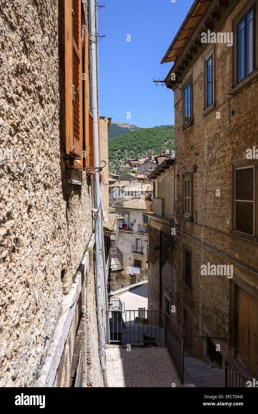 Ruelle pavée étroite dans la ville historique de Scanno Abruzzes en Italie montrant des bâtiments en pierre âgés avec des volets en bois et une vue sur les maisons sur la colline Banque D'Images