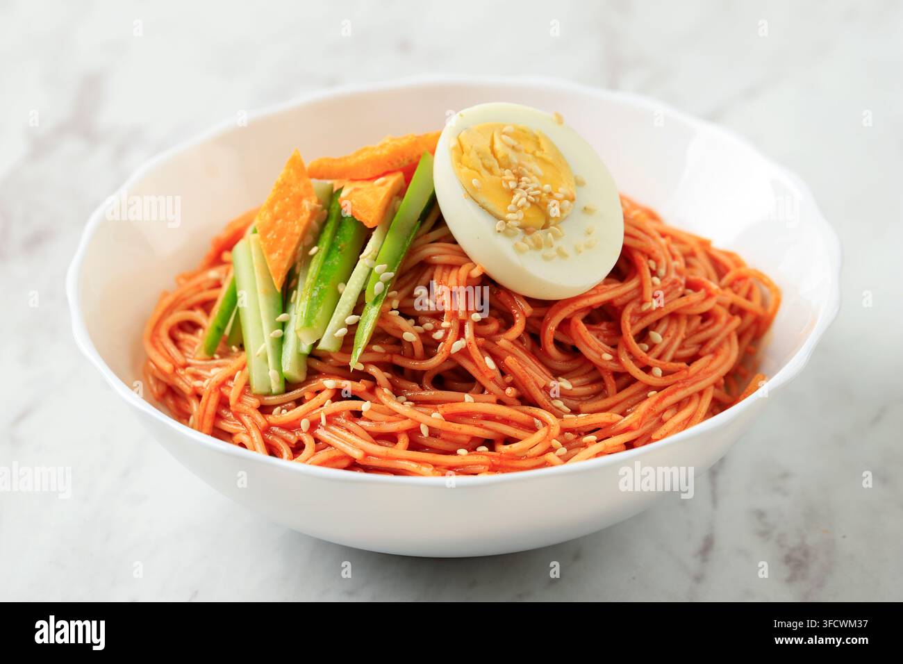 Bibim Guksu coréen dans un bol blanc posé sur une table en marbre Banque D'Images