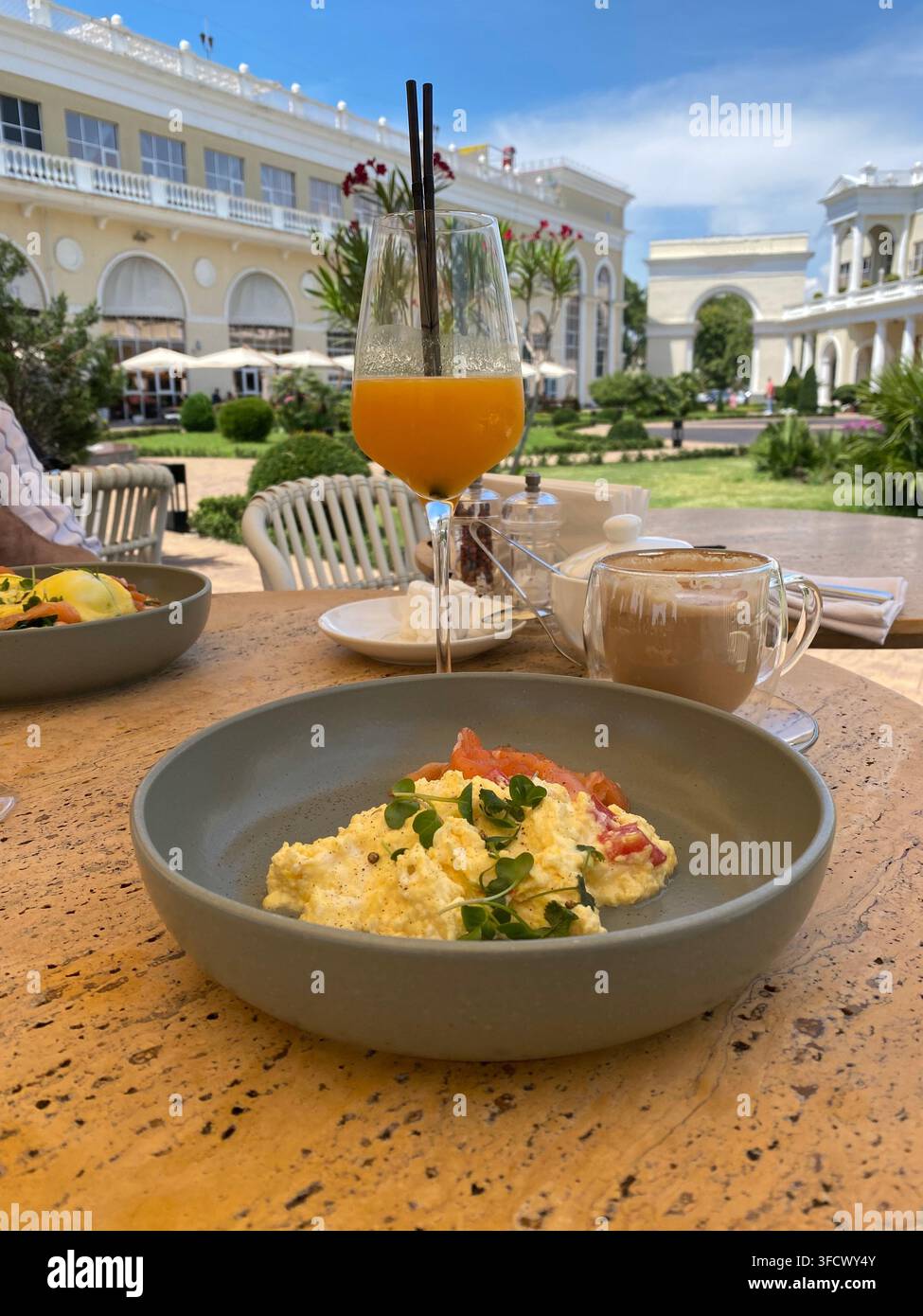 Œufs brouillés, café et jus d'orange servis dans un restaurant extérieur d'un resort - Image de stock capturée avec un smartphone