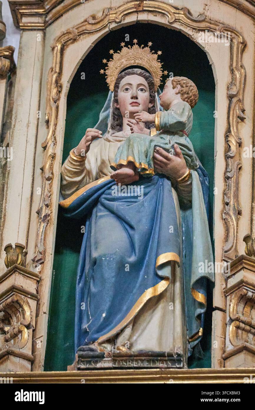 Figure religieuse féminine couronnée tenant un enfant dans une niche dorée ornée à l'intérieur d'une église historique à Baeza, Espagne Banque D'Images