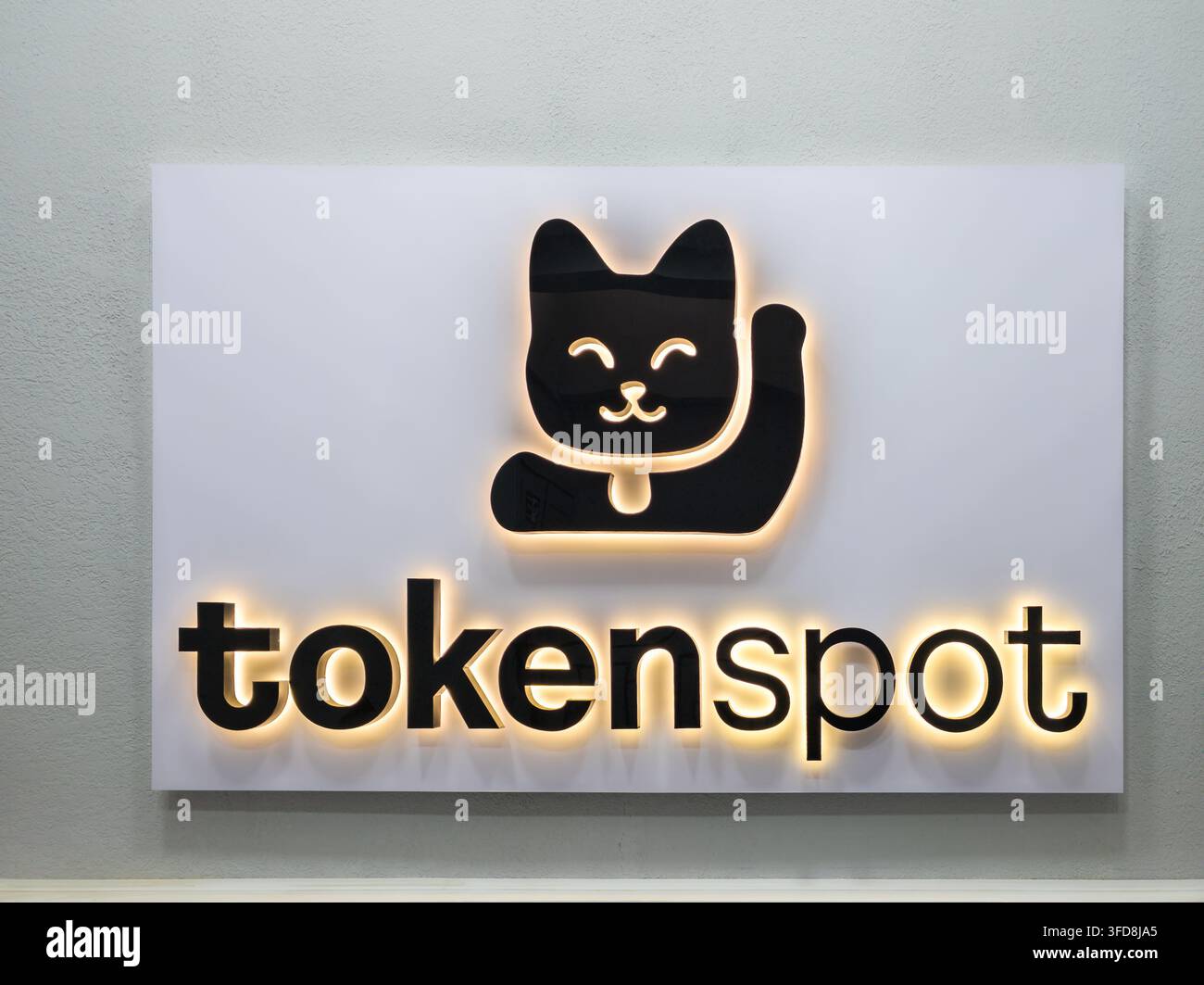 Bichkek, Kirghizistan – 17 février 2025 : Un panneau moderne éclairé affiche le logo « token spot » avec une graphique de chat noir amical. Le panneau est dos Banque D'Images