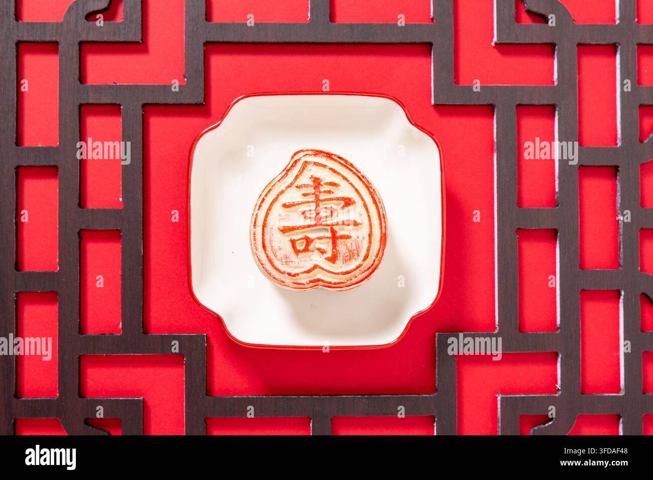 Gâteau de lune chinois traditionnel en forme de pêche de longévité avec des caractères propices Banque D'Images