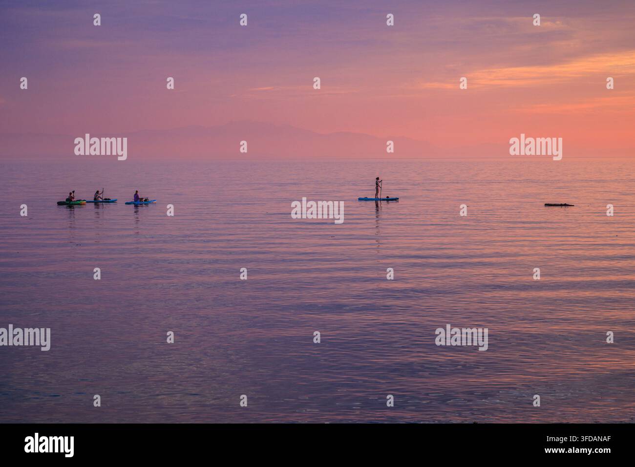 Des gens faisant du kayak et du stand up paddle au coucher du soleil à Davis Bay, Colombie-Britannique, Canada. Banque D'Images