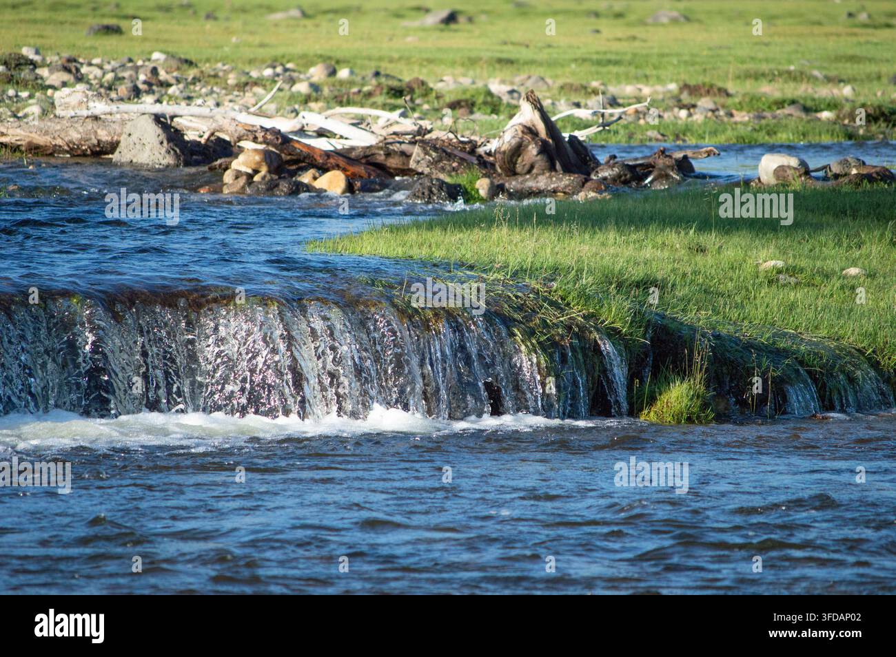 Vallée de l'Orkhon, Mongolie - 5 août 2026 : une petite cascade dévale des bois flottés le long de la berge. Banque D'Images
