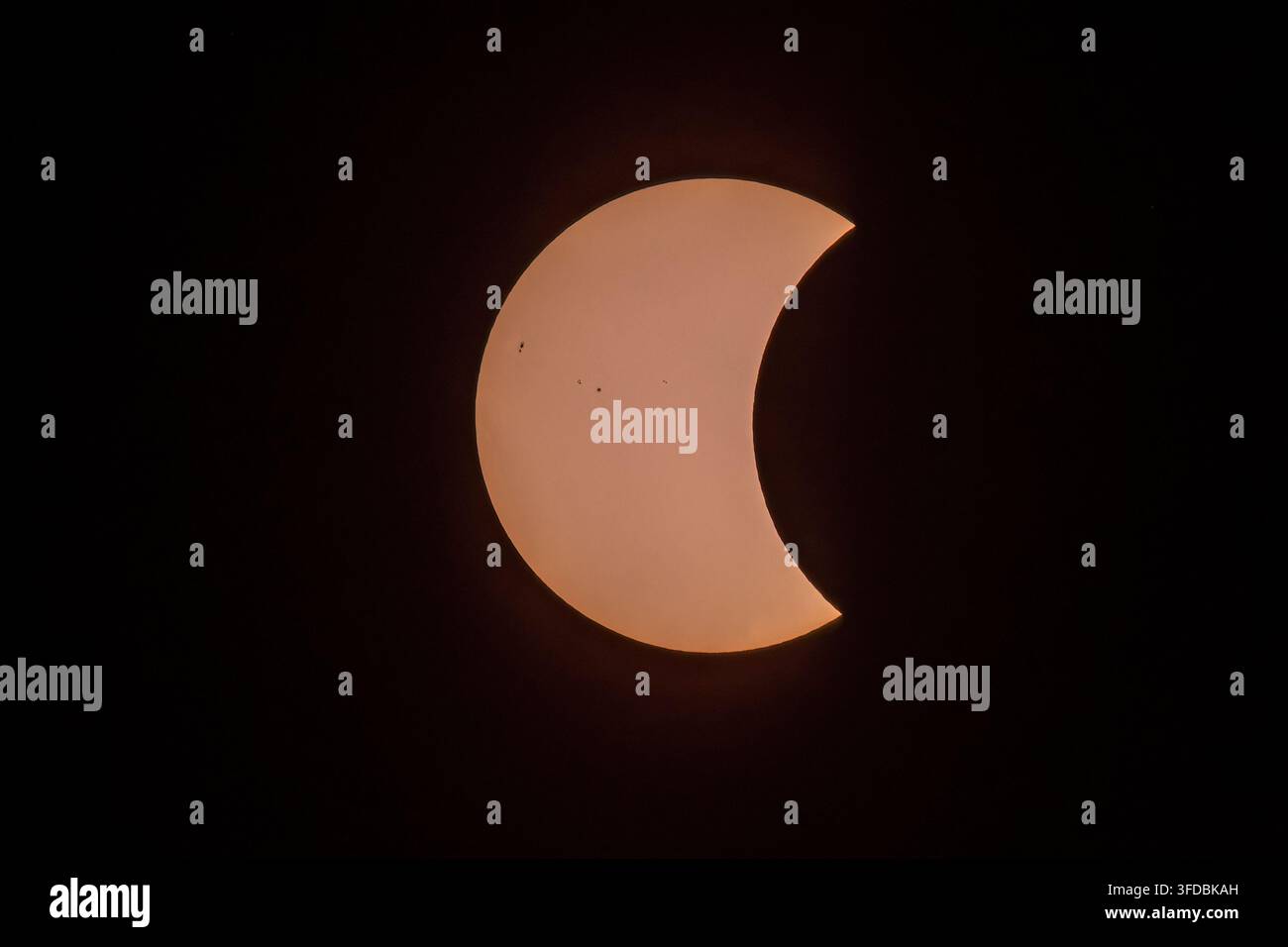 Phase partielle de l'éclipse solaire totale du 12 août 2026 montrant des taches solaires et la silhouette de la lune - astrophotographie. Banque D'Images