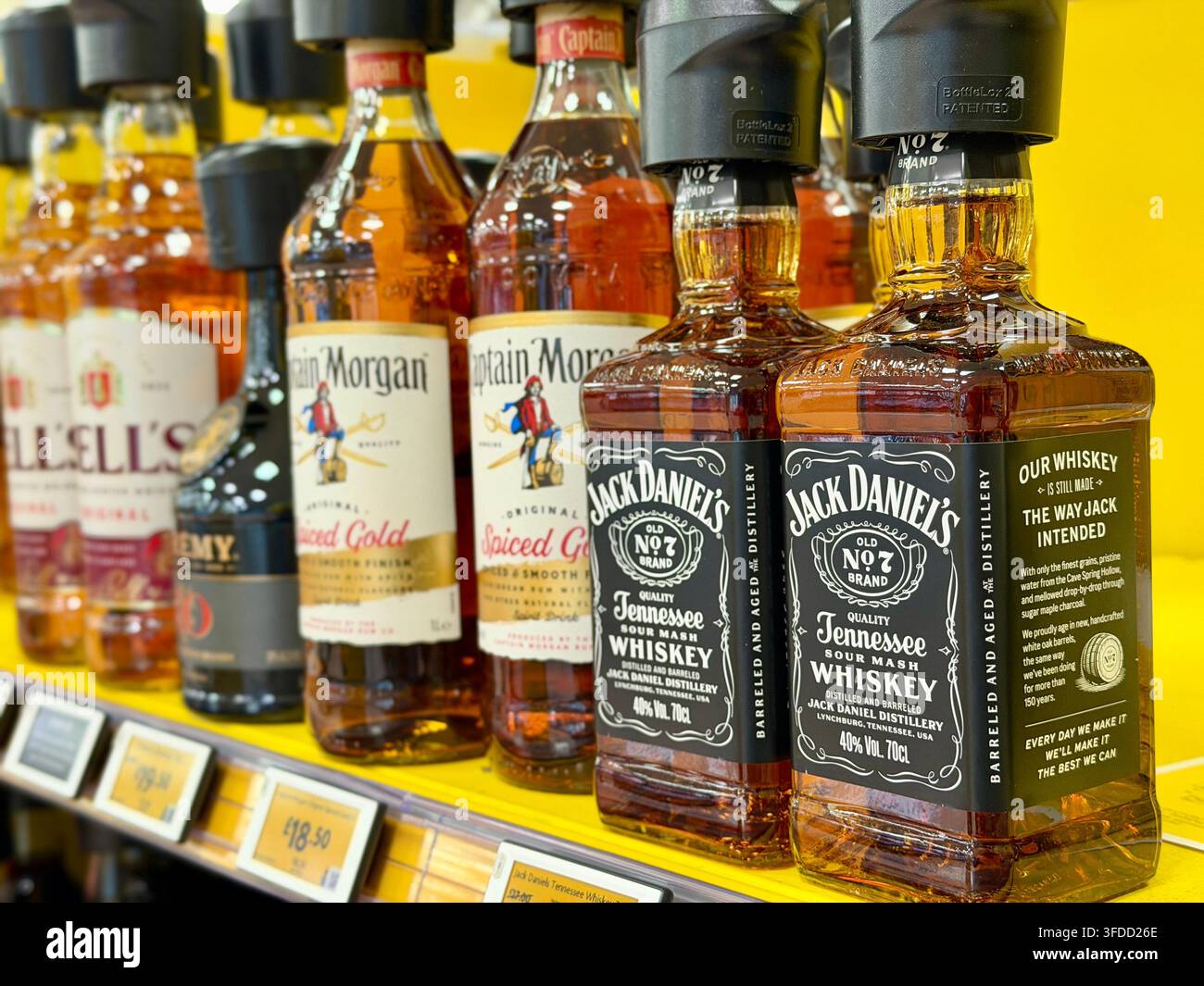 Bouteilles de Jack Daniel’s Tennessee whiskey et de Captain Morgan Spiced Gold rum en promotion dans un supermarché britannique, avec les étiquettes de prix sur les étagères visibles, août 202 Banque D'Images