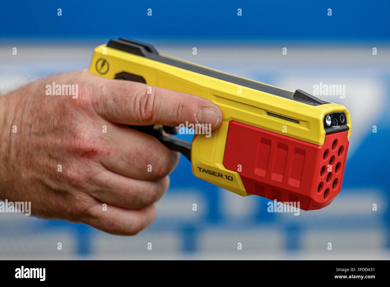 75 ans de police fédérale - Fête citoyenne de la direction de la police fédérale de Hanovre Taser avec un chargeur d'entraînement rouge dans la main d'un policier fédéral. Le Taser est utilisé par les patrouilles de la police fédérale de Hanovre depuis fin 2025. Le lancement de jusqu'à dix électrodes sur une personne habillée s'effectue à une distance de 12 mètres. Un courant de maximum 883 volts et 0,0020 ampères par seconde est appliqué pendant cinq secondes. L'utilisation du Teaser est stockée électroniquement de manière lisible dans l'appareil Axon. Hanovre Direction de la police fédérale de Hanovre, Basse-Saxe, Région de Hanovre Allemagne *** 75 ans de police fédérale : C Banque D'Images