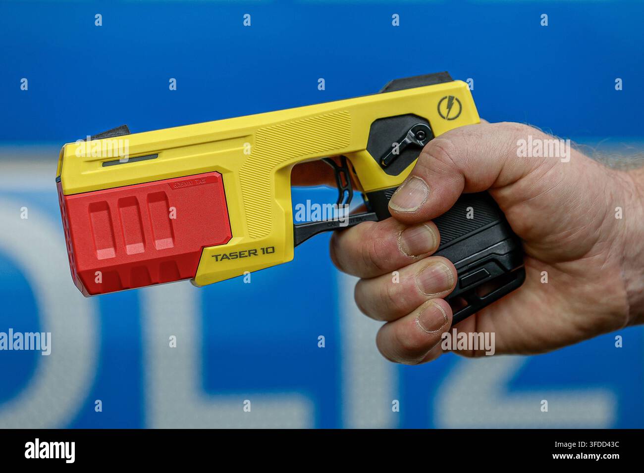 75 ans de police fédérale - Fête citoyenne de la direction de la police fédérale de Hanovre Taser avec un chargeur d'entraînement rouge dans la main d'un policier fédéral. Le Taser est utilisé par les patrouilles de la police fédérale de Hanovre depuis fin 2025. Le lancement de jusqu'à dix électrodes sur une personne habillée s'effectue à une distance de 12 mètres. Un courant de maximum 883 volts et 0,0020 ampères par seconde est appliqué pendant cinq secondes. L'utilisation du Teaser est stockée électroniquement de manière lisible dans l'appareil Axon. Hanovre Direction de la police fédérale de Hanovre, Basse-Saxe, Région de Hanovre Allemagne *** 75 ans de police fédérale : C Banque D'Images