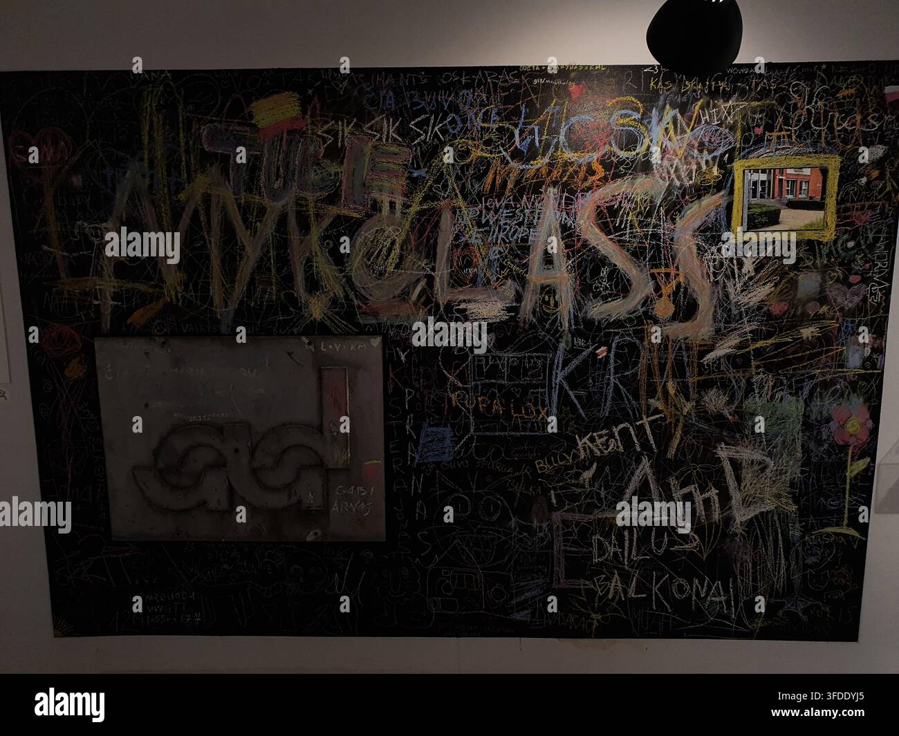 Une grande installation en tableau noir couverte de dessins au crayon épais et colorés, de gribouillis et de texte écrit à la main. La composition met en vedette des éléments grands et proéminents Banque D'Images