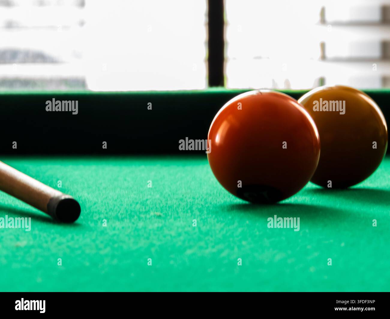 Close-up de boules de billard et queue sur une table en feutre vert. Un plan en mise au point sélective des boules numérotées colorées dispersées sur une table de snooker verte avec Banque D'Images