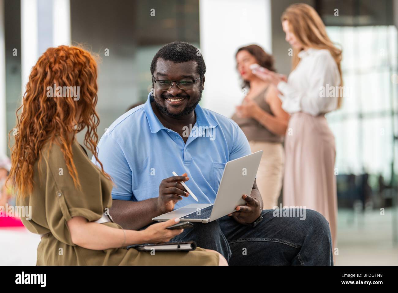 Un homme souriant montre à son collègue l'écran d'un ordinateur portable Banque D'Images