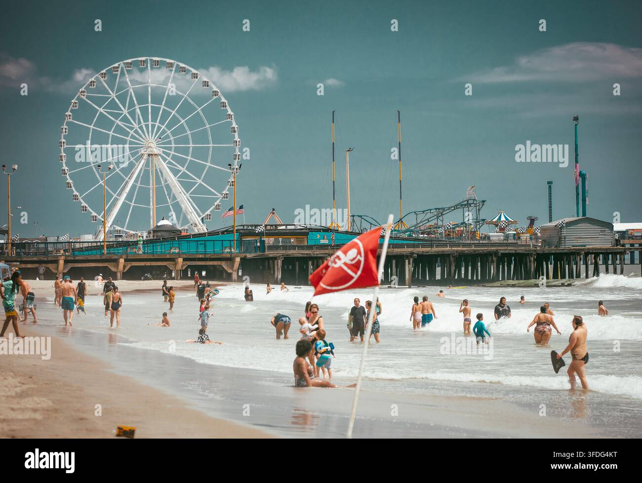 Journée d'été animée à la plage avec une jetée de parc d'attractions Banque D'Images