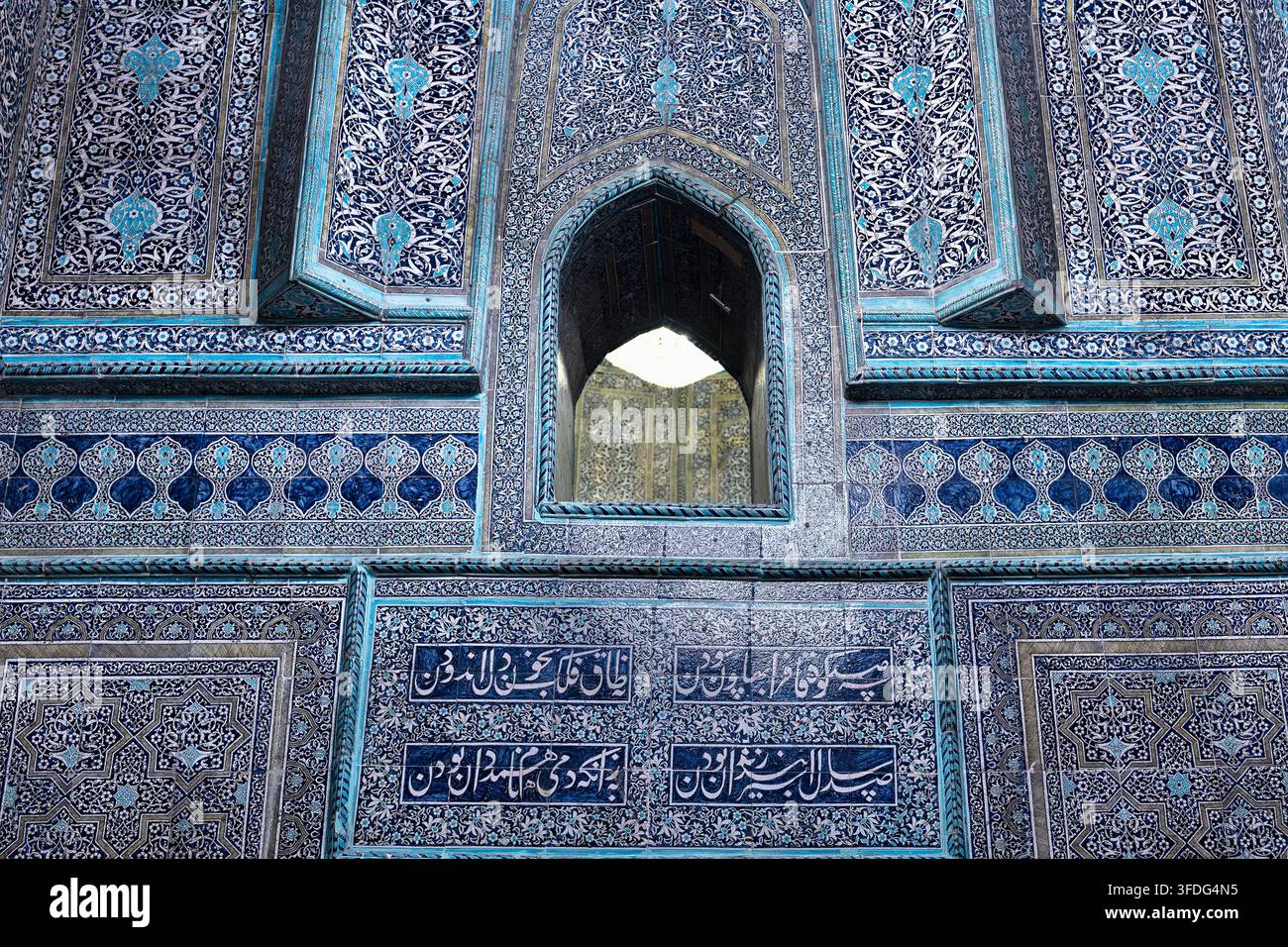 Façade en carrelage bleu orné du mausolée de Pahlavan Mahmud à Khiva avec une fenêtre en arc pointu et des inscriptions calligraphiques. Idéal pour une publication de voyage Banque D'Images