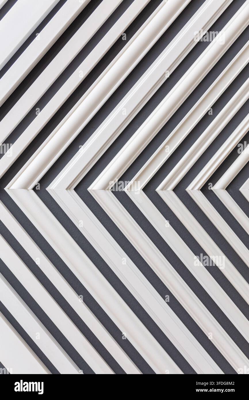 Gros plan de lames en plastique blanc formant un motif diagonal répétitif sur un fond sombre. Banque D'Images