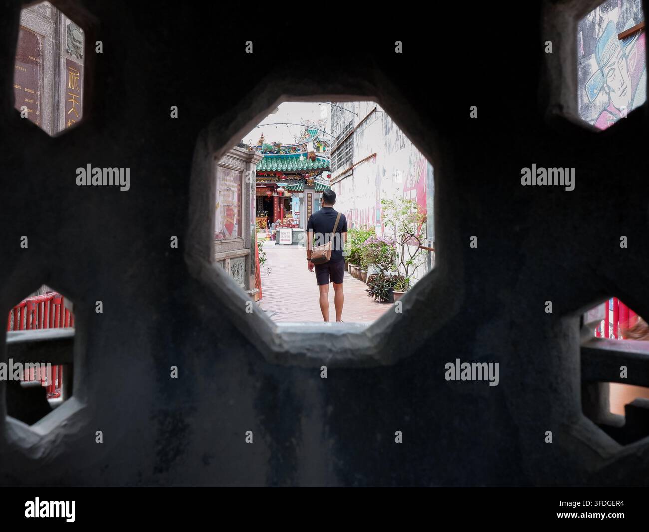 PHUKET, THAÏLANDE - 16 août 2026 : Un touriste marche dans l'allée du sanctuaire Saeng Tham, vieille ville de Phuket. Banque D'Images