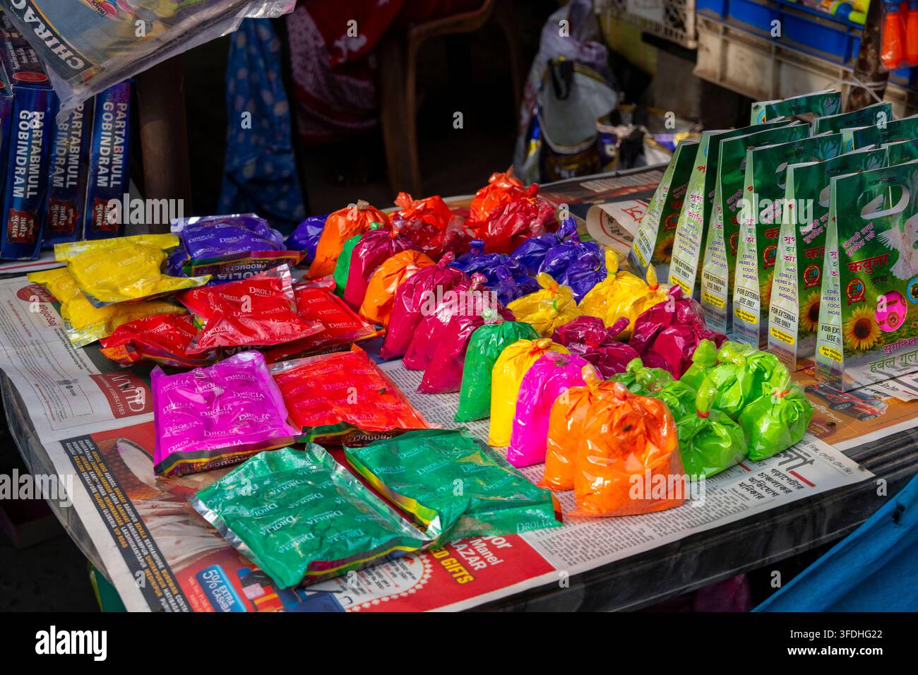 Un assortiment coloré de teintures en poudre pour le festival hindou Holi est soigneusement disposé à la vente dans un marché de rue animé Banque D'Images