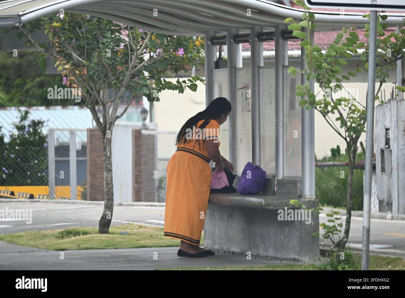 Femme indigène attendant à un arrêt de bus à Chiriquí, Panama Banque D'Images