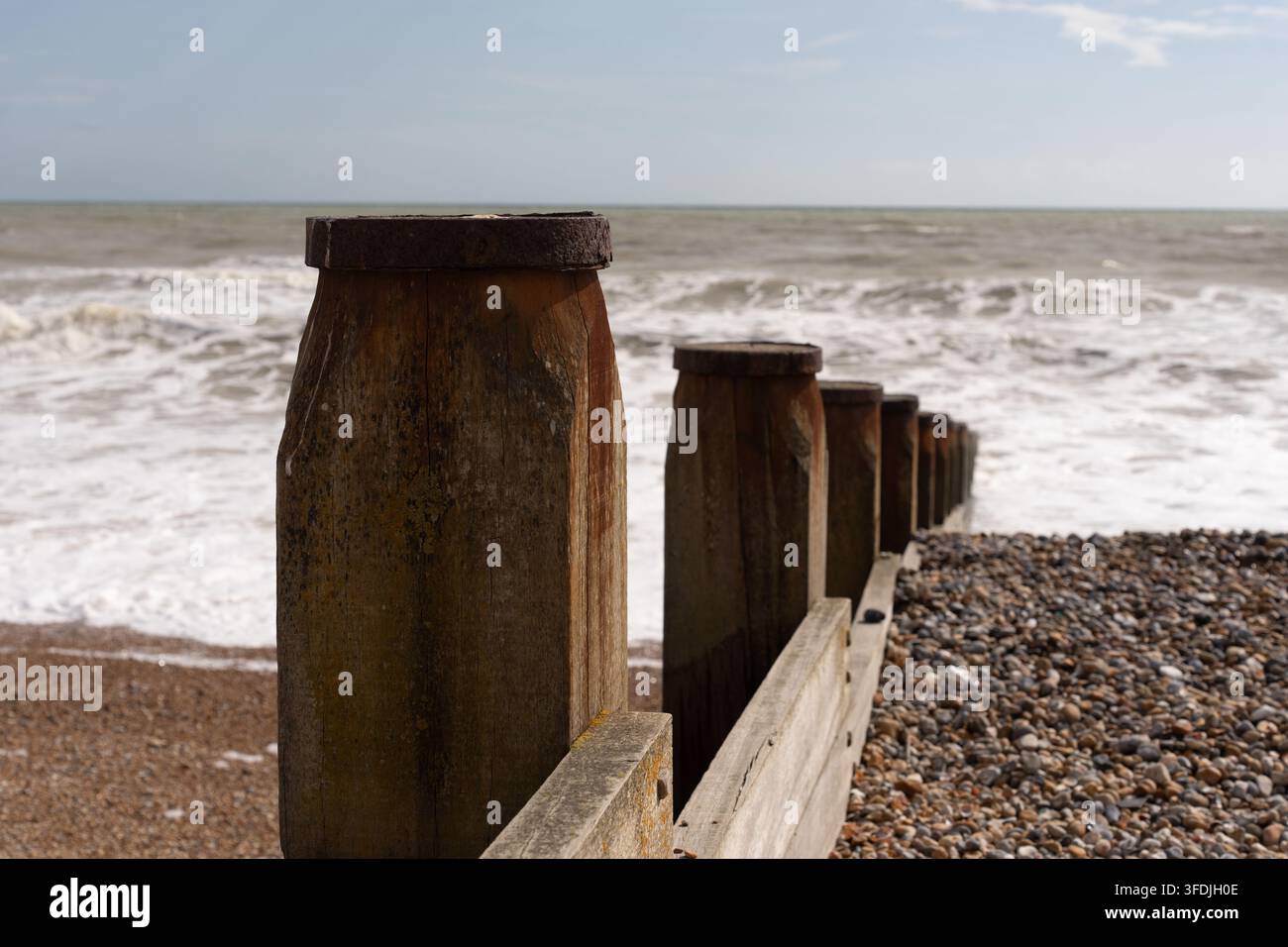 Les groynes en bois de Camber Sands, dans l'East Sussex, empêchent l'érosion côtière en retenant des galets face à la Manche. Banque D'Images