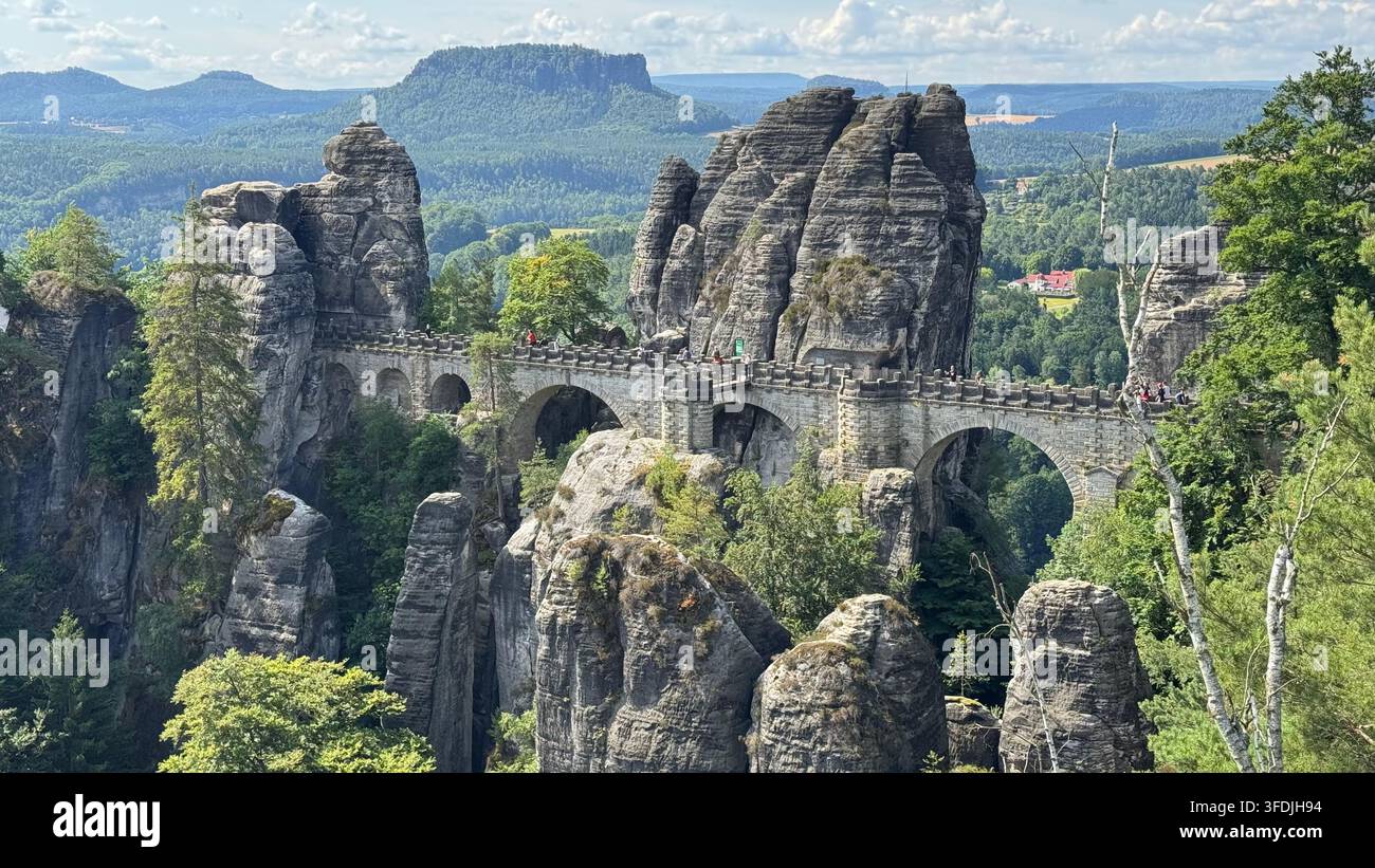 Le pont historique de Bastei traverse des formations de grès dramatiques à côté du château de roche médiéval de Neurathen dans la Suisse saxonne près de Rathen, en Allemagne. - Image de stock capturée avec un smartphone
