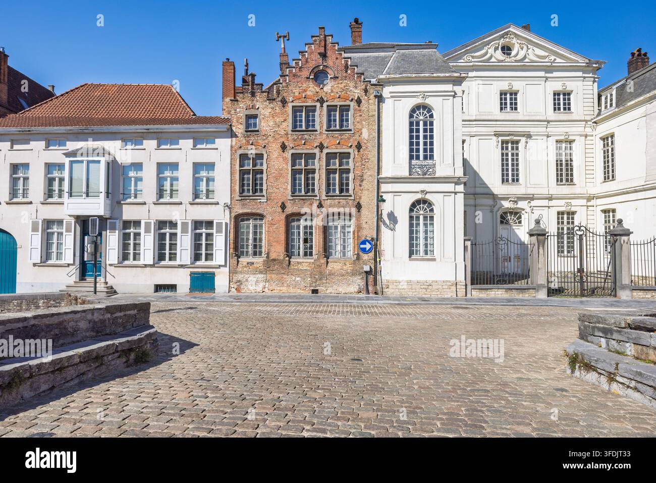 La ville de Bruges en Belgique, Europe. Des lignes d'architecture européenne historique bordent une place pavée sous un ciel bleu clair, mettant en valeur le charme et le style du monde ancien Banque D'Images