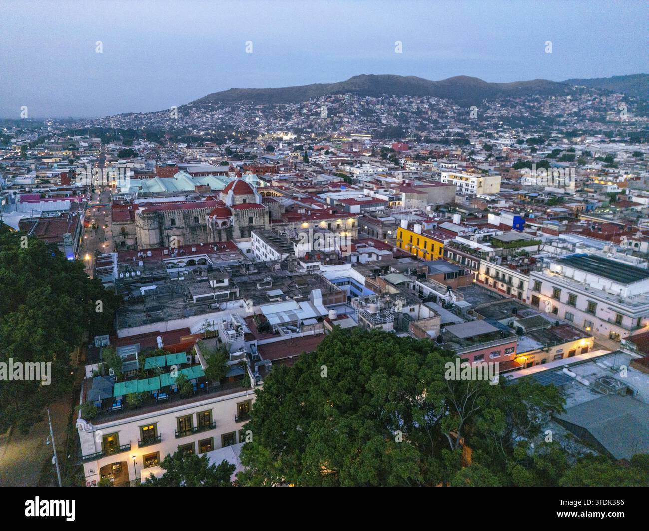 Vue aérienne de la ville coloniale d'Oaxaca au lever du soleil, présentant des toits historiques aux tuiles rouges, un dôme d'église et les montagnes environnantes à Oaxaca, Oaxa Banque D'Images