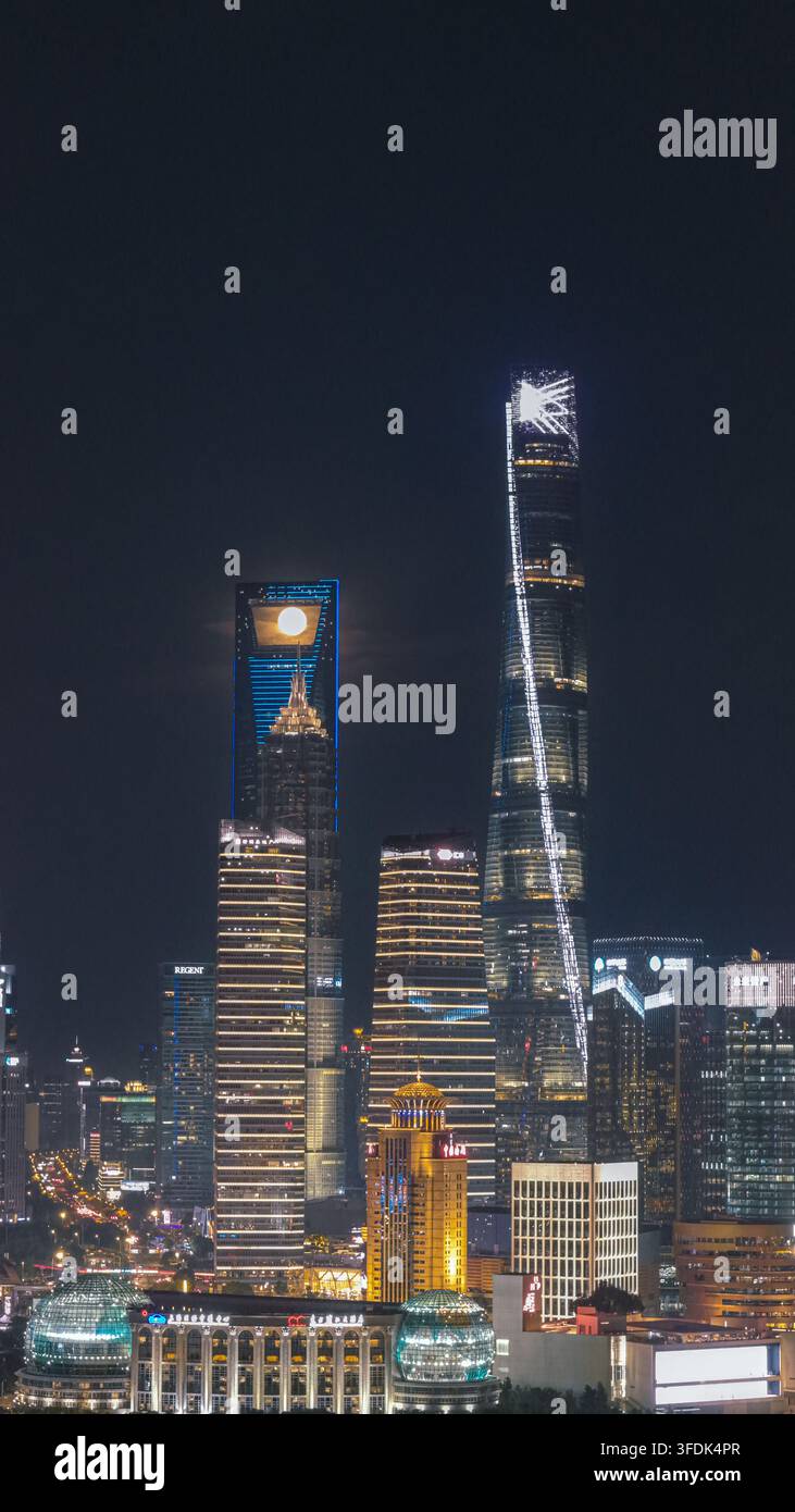 Vue aérienne de l'horizon illuminé de Lujiazui mettant en scène la Tour de Shanghai et une pleine lune se levant derrière les gratte-ciel la nuit à Shanghai, Shanghai Banque D'Images
