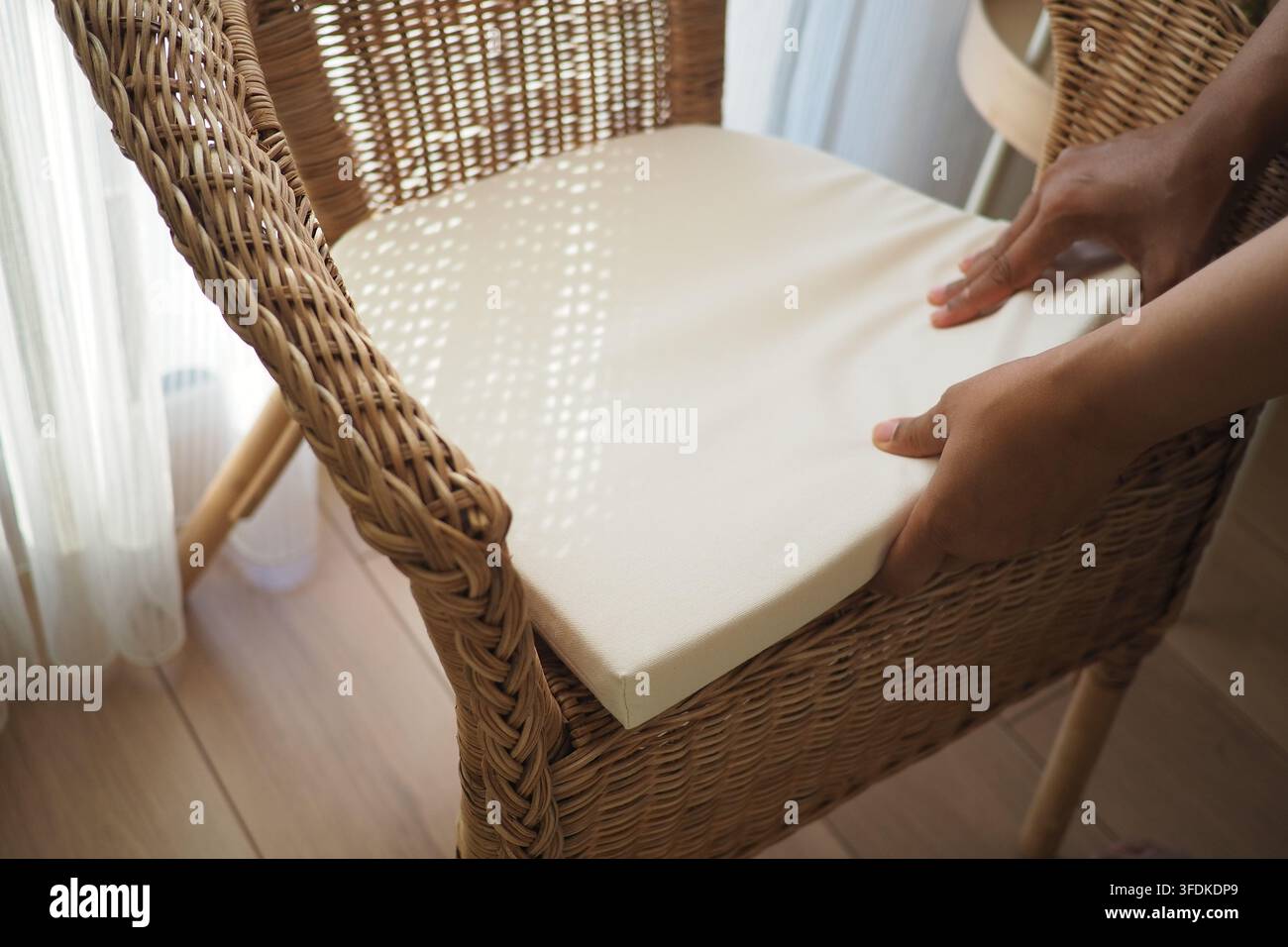 Placer un coussin sur une chaise en osier au soleil Banque D'Images