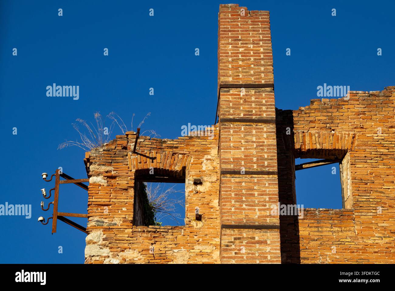 Sabadell, Catalogne, Espagne – Détail des ruines industrielles historiques du Molí d'en Torrella, montrant une haute cheminée en brique, des murs de maçonnerie dégradés, emp Banque D'Images