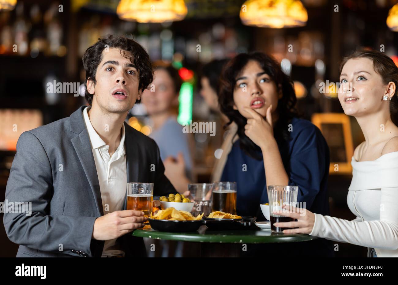 Groupe de jeunes fans de sport bouleversé et inquiétant pendant le match de match à la télévision dans le pub de bière Banque D'Images