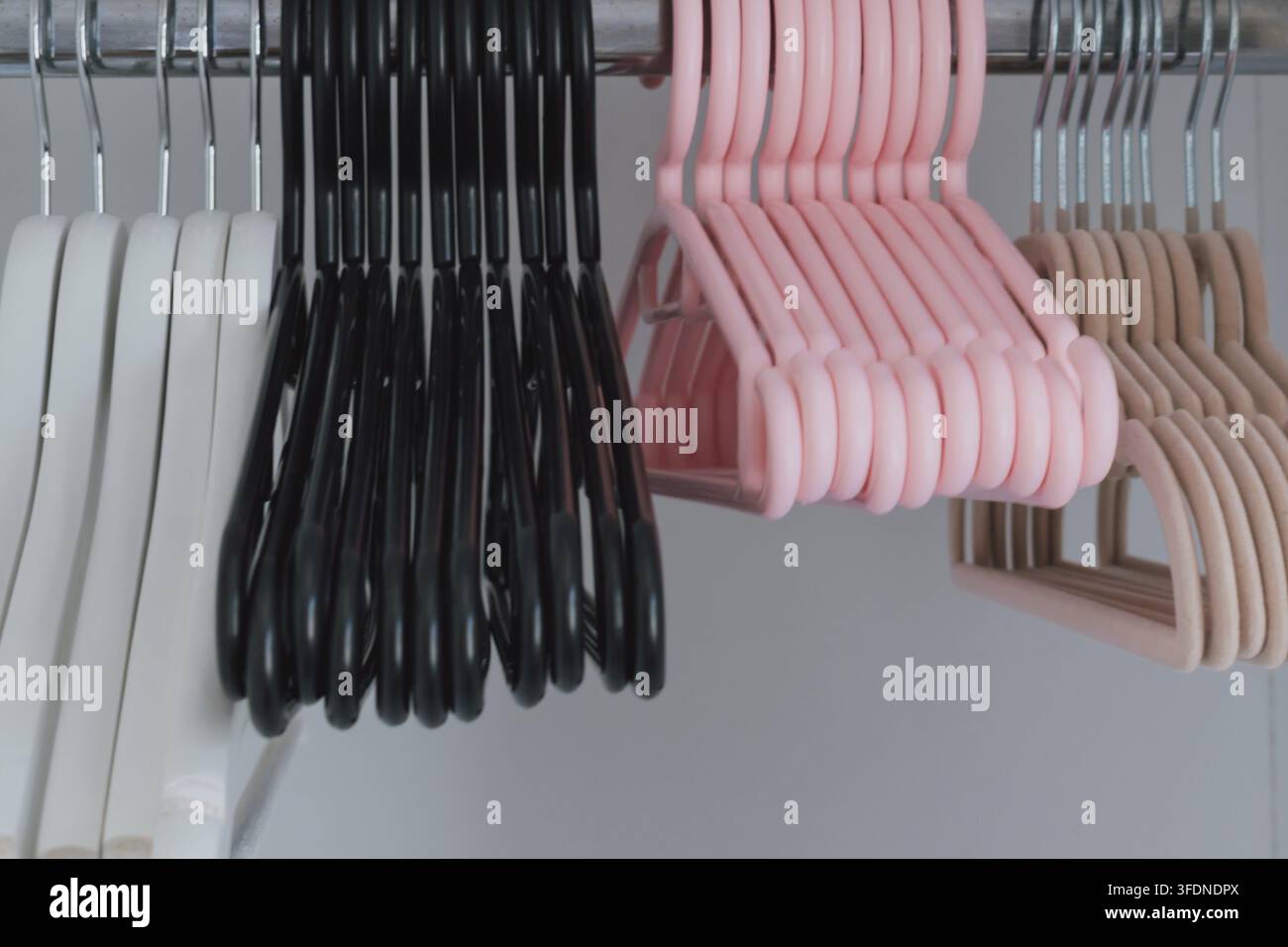 Différents ensembles de cintres dans une garde-robe de diverses formes, matériaux et couleurs. Banque D'Images