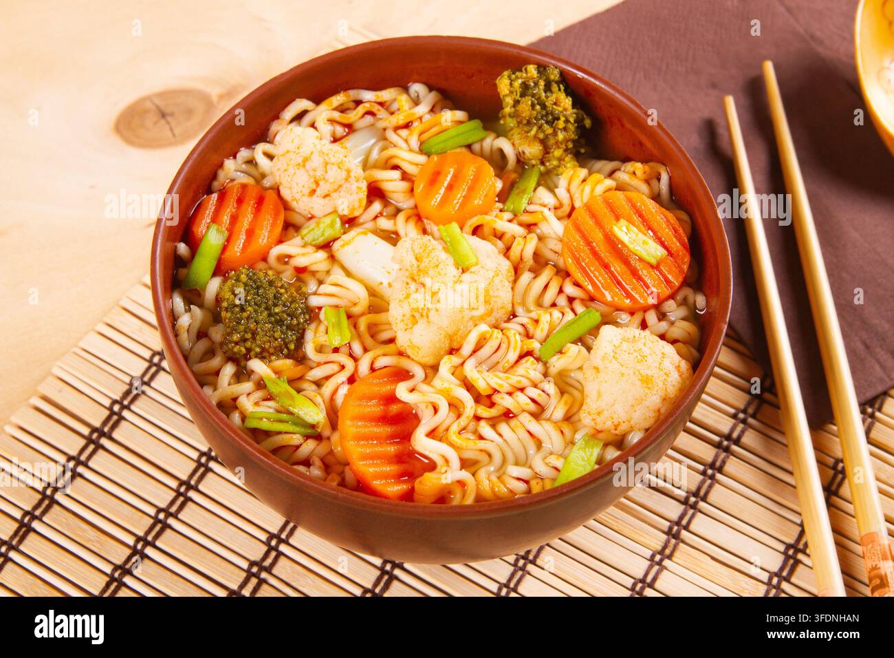 Cuisine végétarienne asiatique mise en valeur par des nouilles udon combinées avec du brocoli et de la carotte. Banque D'Images