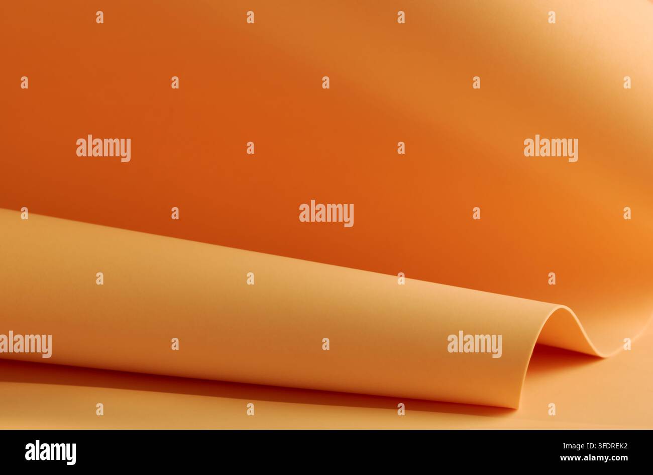 Onde de papier abstraite et enroulée sur un fond orange chaud avec espace de copie pour le branding moderne, les mises en page éditoriales et la publicité produit Banque D'Images