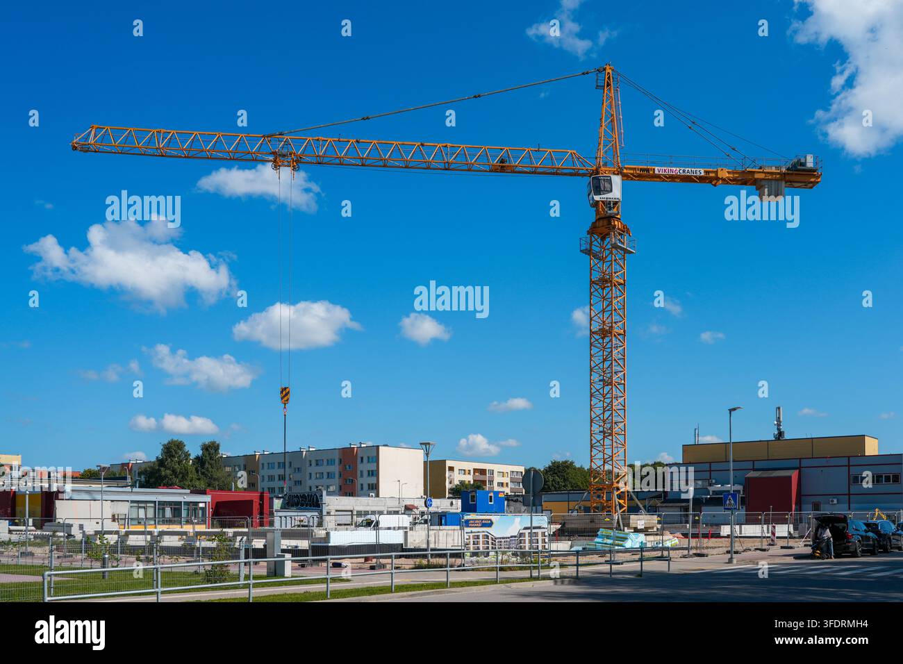 Liepaja, Lettonie – 27 août 2026 : Grue tournante sur un chantier de construction urbain sous un ciel d’été bleu vif Banque D'Images