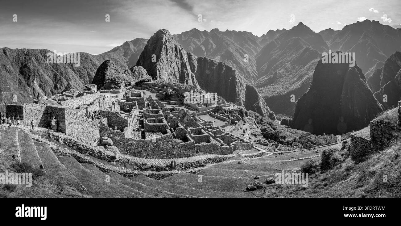 Vue panoramique en noir et blanc des anciennes terrasses en pierre inca et de la citadelle de Machu Picchu encadrées par des pics dramatiques des Andes près de Cusco, au Pérou, évoquant l'histoire Banque D'Images