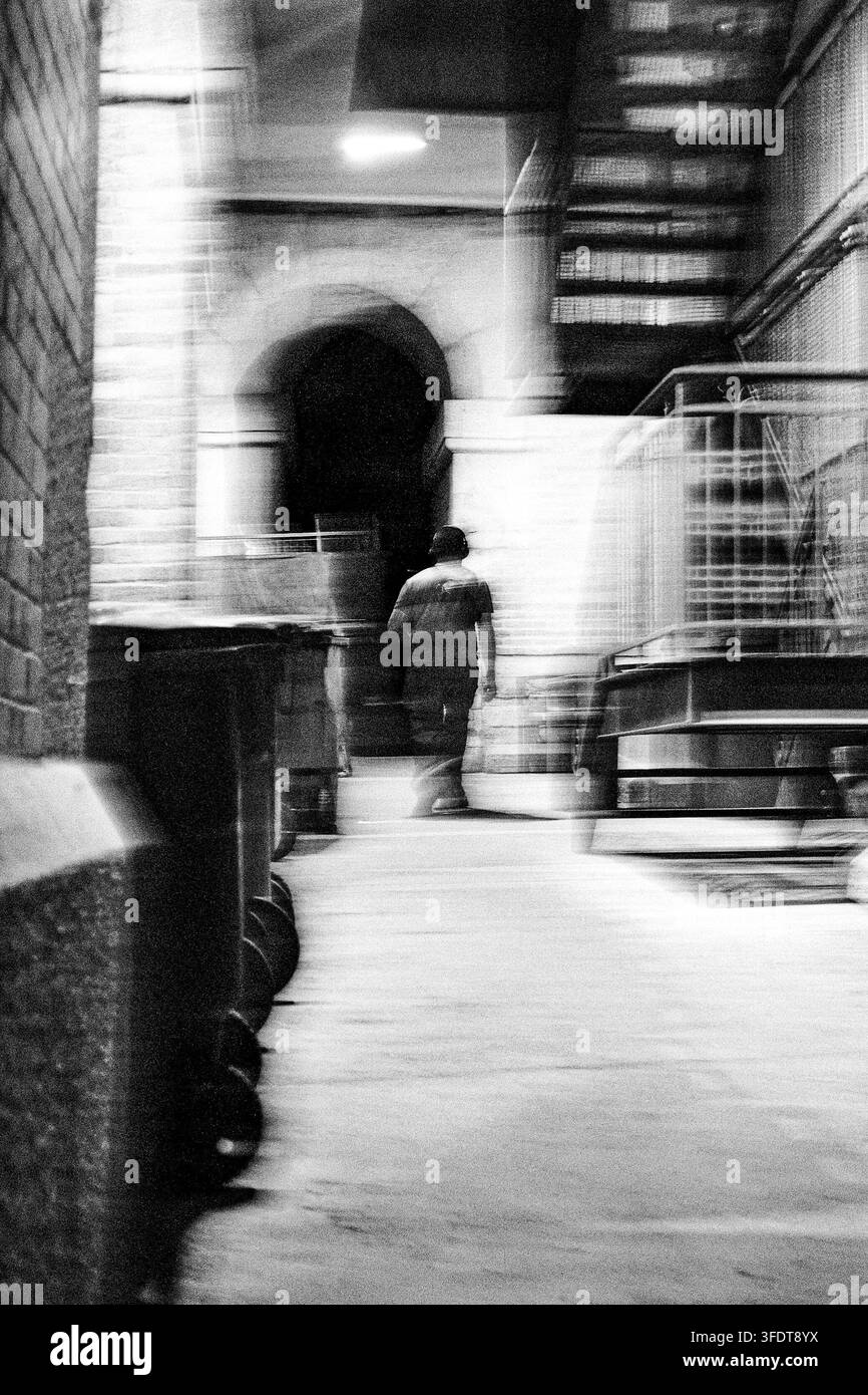 Jeune homme marchant dans la rue dans l'obscurité. Banque D'Images