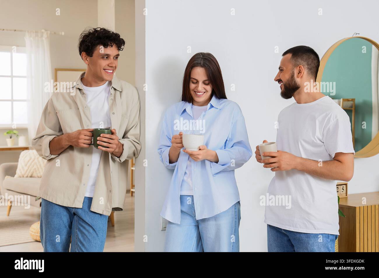 Collaboration au travail et connexion sociale, jeunes collègues divers discutant et buvant du café pendant une pause dans un intérieur de bureau moderne et lumineux Banque D'Images